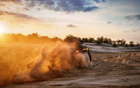 Racing in the sand on a four-wheel drive quad.の写真素材