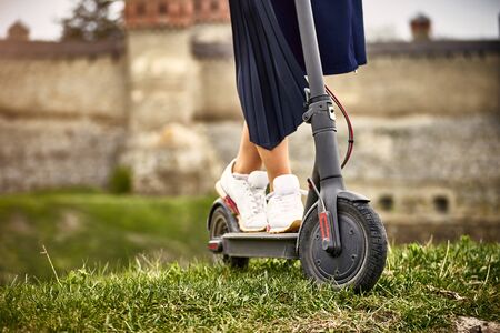Using an electric scooter as a means of transportation on the street.の写真素材