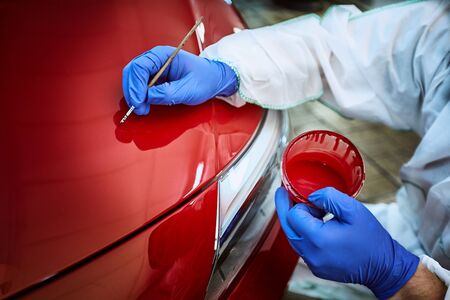Professional painting of a red car on the service