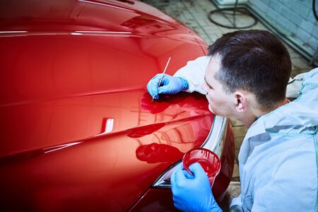 Professional painting of a red car on the service