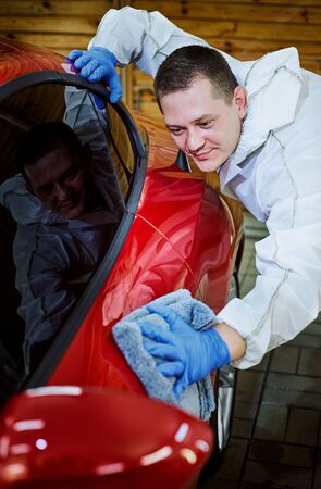 Professional polishing at the service of a red car.の写真素材