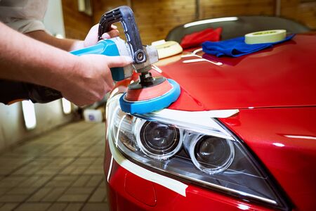 Polishing a red car on a customer service.の写真素材
