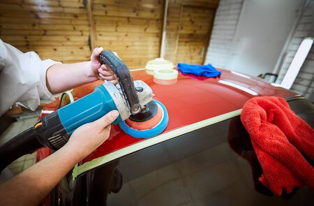 Polishing a red car on a customer service.の写真素材