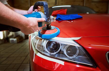 Polishing a red car on a customer service.の写真素材