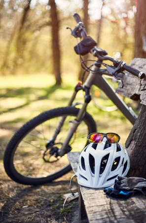 Outfit for bicycles, helmet, gloves on the bench on a sunny day.の写真素材
