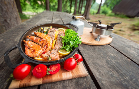 Baked salmon steaks with herbs and asparagus in a black cast iron skillet.の写真素材