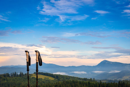 A hiking stick on the background of a picturesque view of mountains with peaks.の写真素材