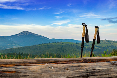 A hiking stick on the background of a picturesque view of mountains with peaks.の写真素材