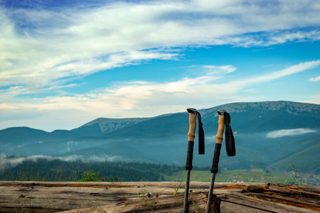 A hiking stick on the background of a picturesque view of mountains with peaks.の写真素材