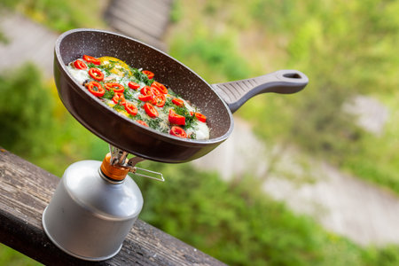 Cooking eggs with vegetables in a frying pan.の写真素材