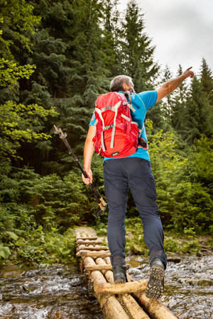 Hiking in mountainous terrain with a backpack and trekking poles.の写真素材