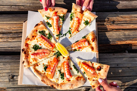 Pizza with shrimp and seafood on the table in a beautiful place.の写真素材