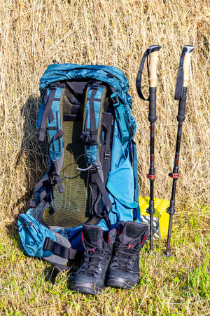 Hiking with a backpack and trekking poles in the mountains. Camping and trekking equipmentの写真素材