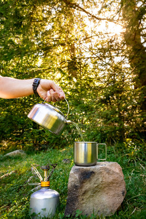 Making tea in a kettle while hiking in the mountains.の写真素材