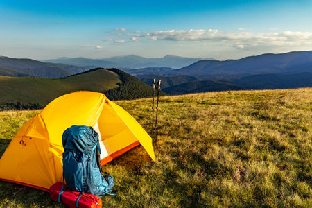Hiking in the mountains in summer with a backpack and a tent. Beautiful landscape in the mountains.の写真素材