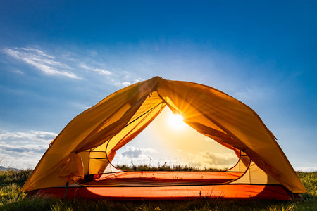 Sunset on the top of the mountain. A tent on the background of a mountain landscape.の写真素材