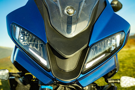 Front of motorcycle with headlight, side view.
