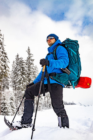 Winter hiking in the mountains with a backpack and snowshoes.の写真素材