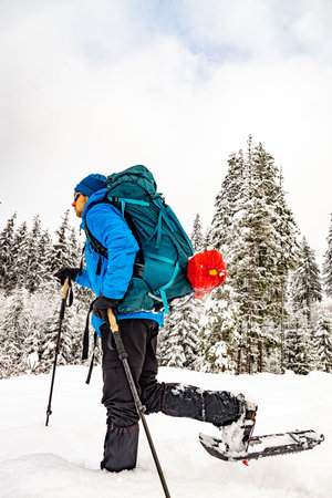 Winter hiking in the mountains with a backpack and snowshoes.の写真素材