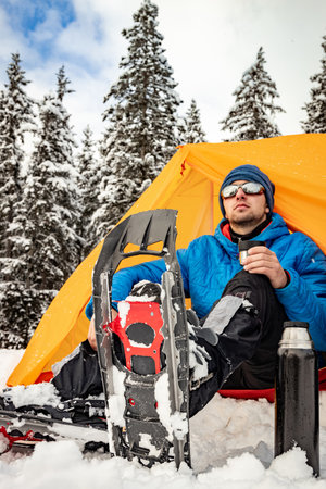 Hiking in the mountains with snowshoes and a backpack and a tent, hiking equipment.の写真素材