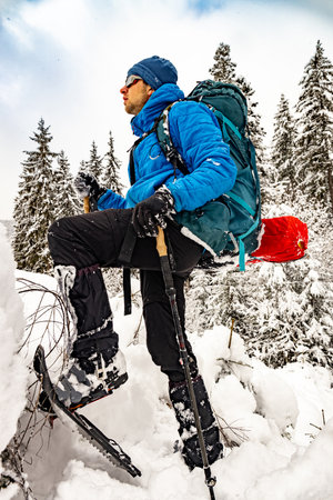 Winter hiking in the mountains with a backpack and snowshoes.の写真素材