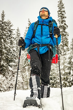 Winter hiking in the mountains with a backpack and snowshoes.の写真素材