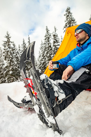 Hiking in the mountains with snowshoes and a backpack and a tent, hiking equipment.の写真素材