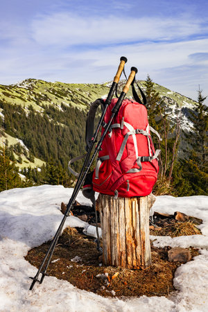 Hiking in the mountains in spring with a backpack and trekking poles along a mountain ridge.の写真素材