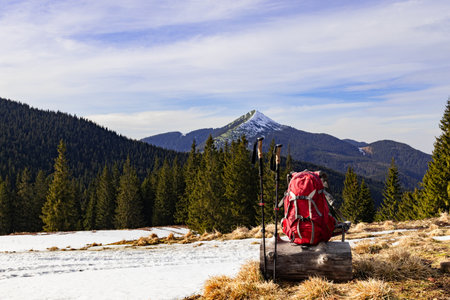 Hiking in the mountains in spring with a backpack and trekking poles along a mountain ridge.の写真素材