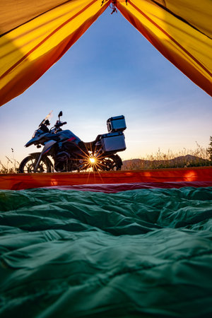 Camping with a motorcycle with a yellow tent in the mountains.の写真素材