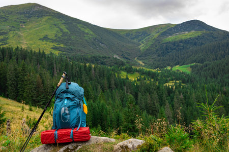 Summer hiking in the mountains with a backpack and a tent. Beautiful mountain landscape.