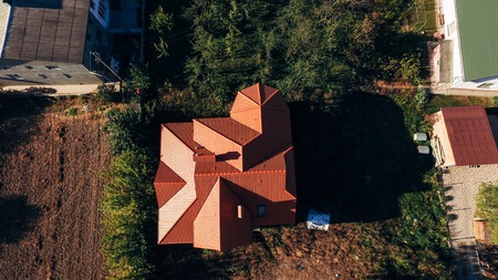 Aerial view of the red roof of a new house in a small village. Tiled roof