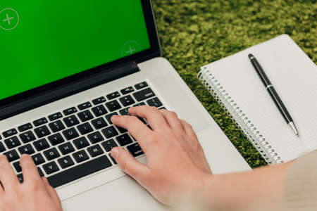 Close-Up Shot of Notepad and Human Hands Placed Over Laptopの写真素材