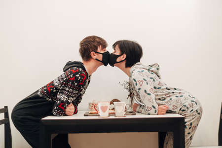 Girl and Guy Kissing in Masks on Quarantine COVID-19の写真素材
