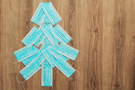 Christmas Tree Made of Medical Masks on a Brown Background with Copy Spaceの写真素材