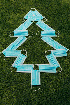 Christmas Tree Made of Blue Medical Masks on a Green Backgroundの写真素材