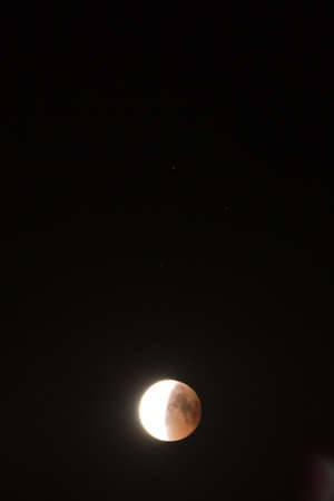 Lunar eclipse in the black night skyの写真素材