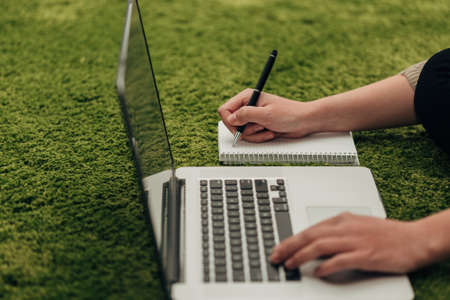 Girl Writes Notepad Information from a Laptop Screen
