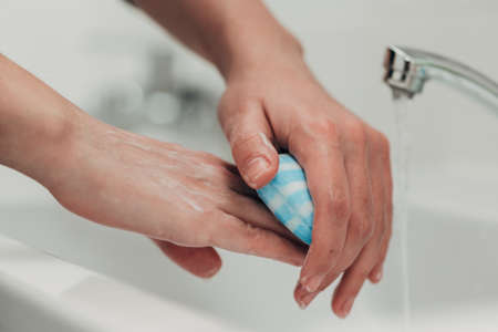 The Girl Washes Her Hands to Avoid Infection With the Virusの写真素材