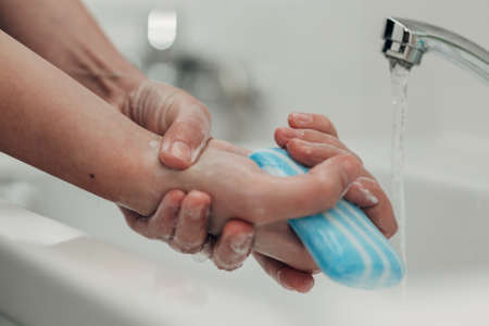 The Girl Washes Her Hands to Avoid Infectionの写真素材
