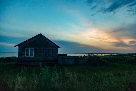 Old Wooden House by the Sea. Wonderful Landscape with a Beautiful Sunsetの写真素材