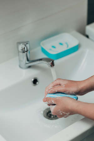 The Girl Washes Her Hands to Avoid Infection With the Virus COVID-19の写真素材