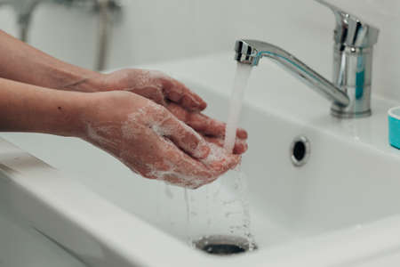 The Girl Washes Her Hands to Avoid Infection With the Virus COVID-19の写真素材