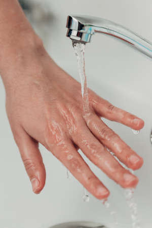 The Girl Washes Her Hands to Avoid Infection With the Virus COVID-19の写真素材