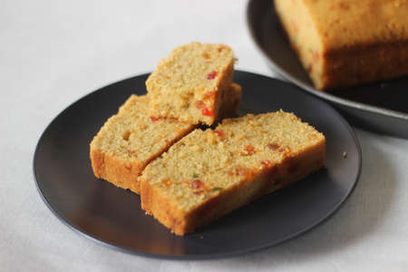 Slices of tutti frutti cake loaf made with whole wheat flour. Shot on white background