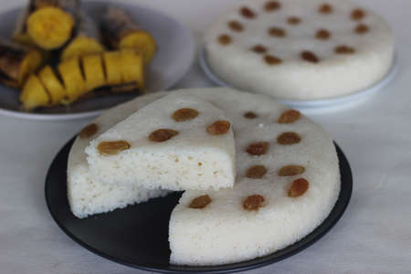 Spongy steamed rice cakes prepared with a fermented batter of rice and coconut served with steamed plantain. A healthy breakfast combination of Kerala locally known as vattayappam and steamed ethakka