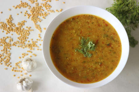 Boiled lentils tempered with garlic and spices. A favourite side dish from India popularly known as Yellow Daal Tadka. Shot on white backgroundの写真素材