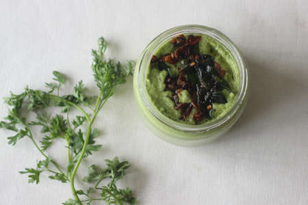 Homemade fresh spicy and hot condiment made with coriander, coconut shallots and green chilly. Locally known as coriander coconut chutney. Shot on White background.の写真素材