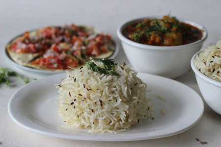 Indian dish made of basmati rice flavoured with cumin seeds and spices. Locally known as jeera rice served with Bottle Gourd Curry with Lentils and Crisp and fried papads topped with masala fillingの写真素材