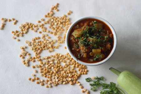 One pot chickpea lentil dish cooked with bottle gourd onions tomatoes and spices. Shot on white background.の写真素材